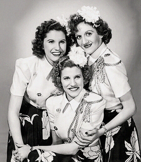The Andrews Sisters: Maxene (top left), LaVerne (top right), and Patty (center), October 1943 (public domain via Billboard 1943 Music Yearbook and Wikipedia)