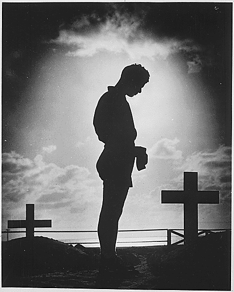 US Coast Guardsman honors the fallen in the Pacific, Memorial Day, 30 May 1944 (US Coast Guard photo)