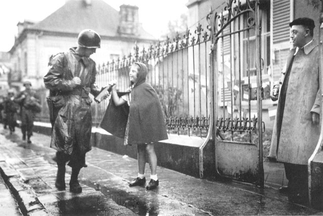 T/Sgt. Joe Trdenic of US 36th Infantry Division receives gift from 11-year-old Therese Grenier in Luxeuil, France, 16 Sept 1944 (US Army Center of Military History)