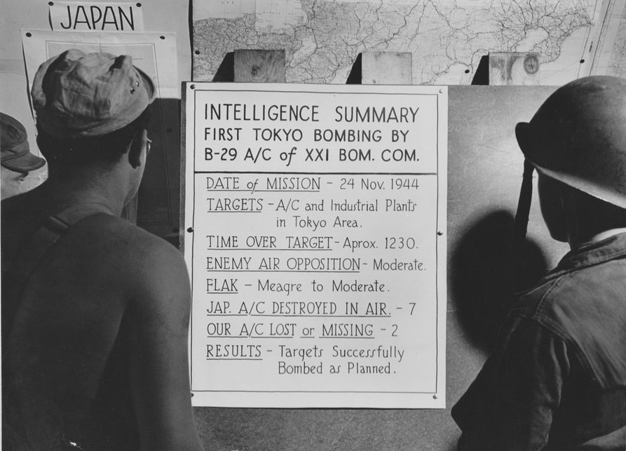 US airmen reading a bulletin announcing their Saipan-based unit's first bombing of Tokyo, Japan on 24 Nov 1944 (US National Archives)