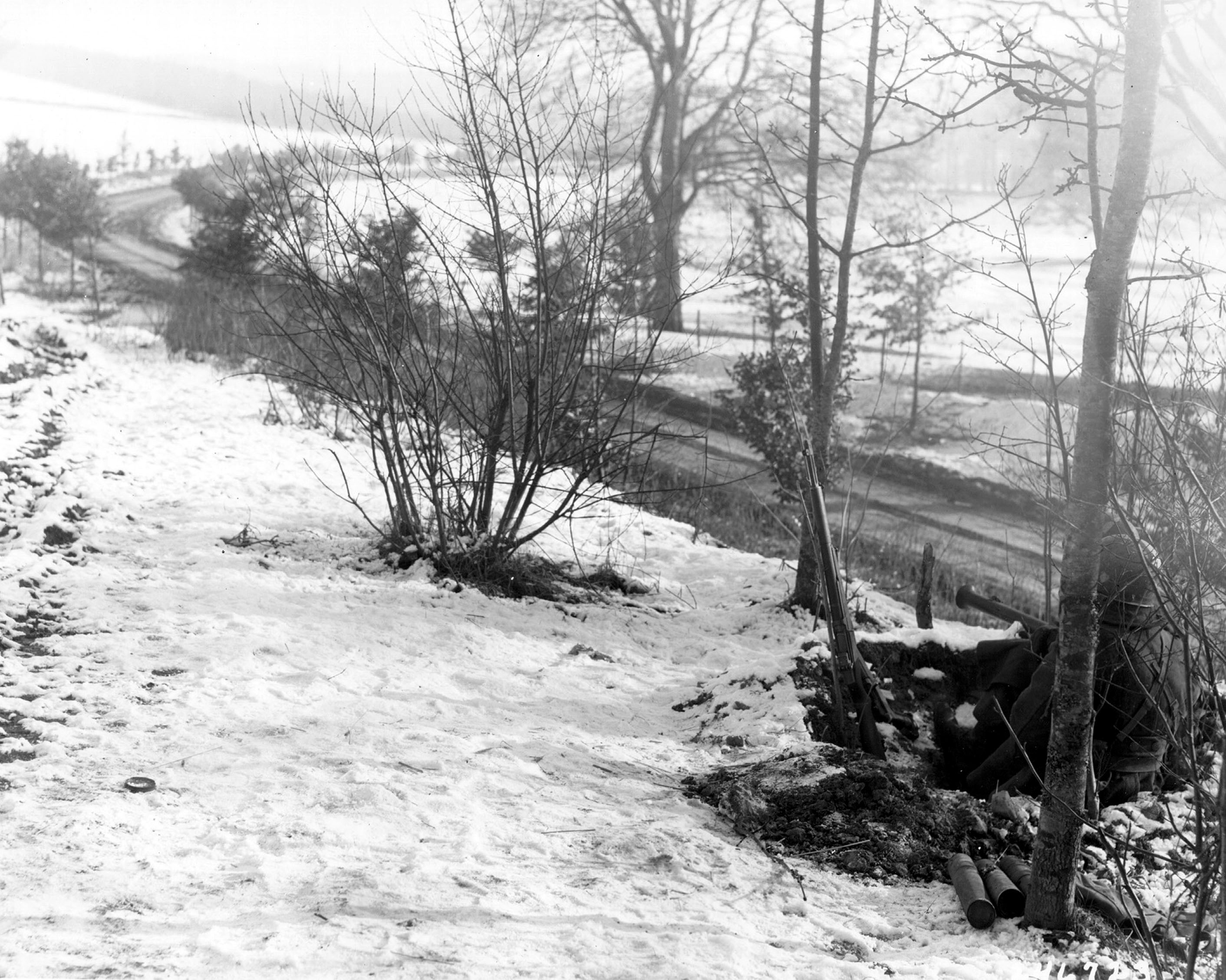 Two soldiers of US 101st Airborne Division with bazookas guard road leading to Bastogne, Belgium, 23 Dec 1944 (US Army Center of Military History)