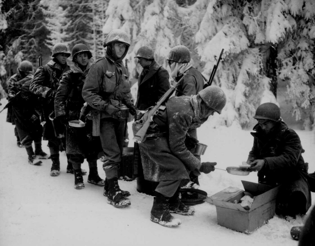 Men of the US 347th Infantry Regiment taking a meal break while en route to La Roche, Belgium, 13 Jan 1945 (US National Archives: 111-SC-198849)