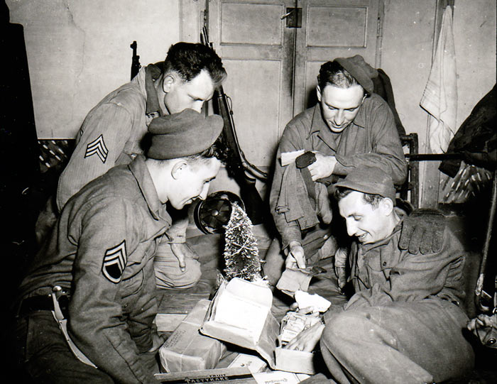 Troops of US 3rd Infantry Division (S/Sgt. John Suchanek, Pfc. Joseph Pierro, Sgt. Charles Myrich, Sgt. Leon Oben) open Christmas gifts from home, Pietramelara, Italy, 16 December 1943 (US Army Center of Military History)
