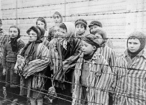 Child survivors of Auschwitz, 27 Jan 1945; Still photograph from Soviet film of the liberation of Auschwitz, taken by the film unit of the First Ukrainian Front (public domain via United States Holocaust Memorial Museum, courtesy of Belarussian State Archive of Documentary Film and Photography)