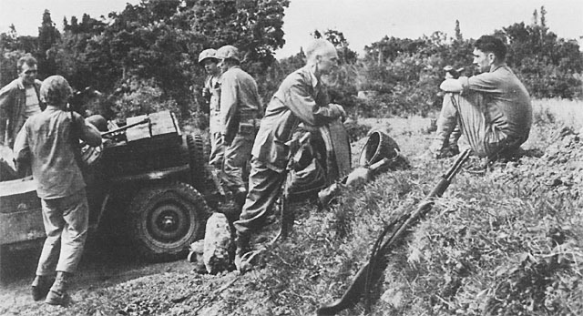 Ernie Pyle (center) talking to a Marine on Okinawa a few hours after its invasion, April 1945 (US Army Center of Military History)