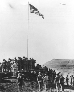 Flag raising at US Headquarters on Iwo Jima after US Navy military government is established, 14 Mar 1945. (US Naval History and Heritage Command: NH 104584)