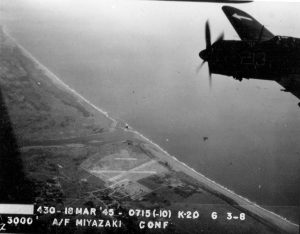 Strike photo taken by aircraft from USS Bunker Hill showing an SB2C Helldiver of Squadron VB-84 over Miyazaki Airfield on southern Kyushu, Japan, 18 Mar 1945 (National Museum of Naval Aviation)