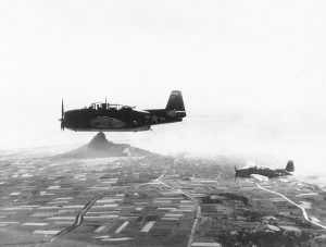 TBM Avenger torpedo planes of Composite Squadron 84 from USS Makin Island flying over Ie Shima, Ryukyu Islands, Japan, 16 Apr 1945 (US Naval History & Heritage Command: NH 69420)