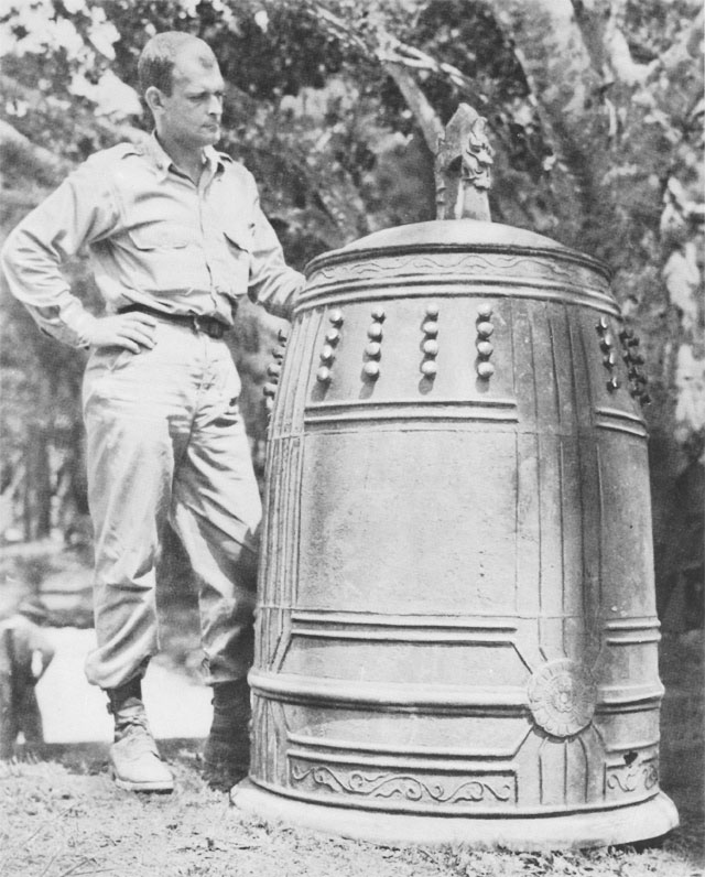 American officer standing by the bell from Shuri Castle on Okinawa, 1945 (US Army Center of Military History)
