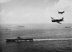 US Navy TG 38.3 off Okinawa, May 1945. US Navy Curtiss SB2C-4 Helldiver dive bombers from carrier USS Essex. Background: battleship USS Washington, an Essex-class carrier, and an Independence-class light carrier (US Navy photo 1996.253.360)