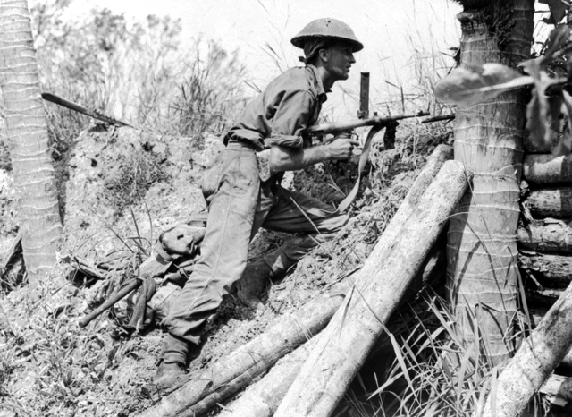 Soldier of the Australian 2/43rd Battalion armed with an Owen Gun in a bomber dispersal bay at Labuan airstrip, Brunei, Borneo, 10 June 1945. (Australian War Memorial: 018637)