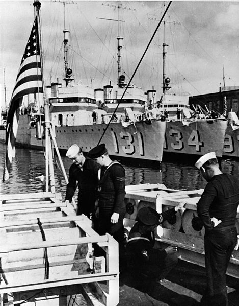 Royal Navy and US Navy sailors inspect depth charges aboard Wickes-class destroyers in 1940. In the background are USS Buchanan (DD-131), and USS Crowninshield (DD-134). On 9 September 1940 both were transferred to the Royal Navy. (Library of Congress) 
