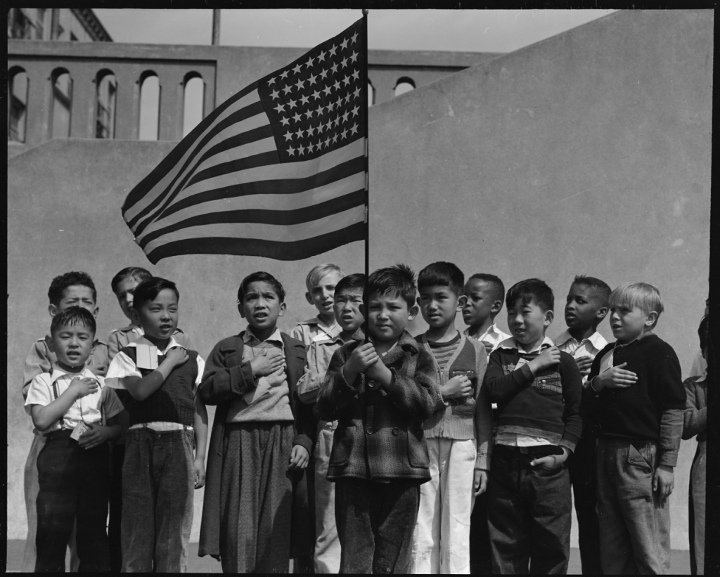 Students at Raphael Weill Public School, Geary & Buchanan Streets, San Francisco, say Pledge of Allegiance, 20 April 1942; students pictured of Japanese ancestry would soon be sent to War Relocation Authority camps (Photo: Dorothea Lange. US National Archives: 210-G-C122)