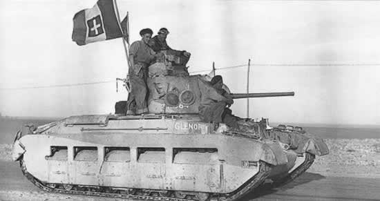 Matilda tank en route into Tobruk, Libya, 24 Jan 1941; note British soldiers displaying a captured Italian flag (Imperial War Museum: 4700-32 E 1772)