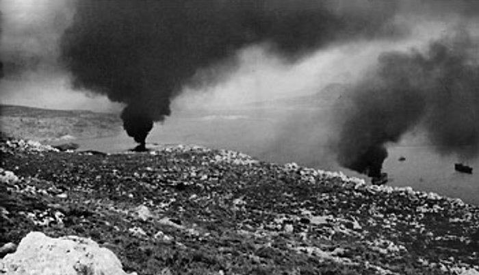 The harbor at Suda Bay, Crete, where two ships, hit by German bombers, burn themselves out, May 1941 (Imperial War Museum: E 3039E)