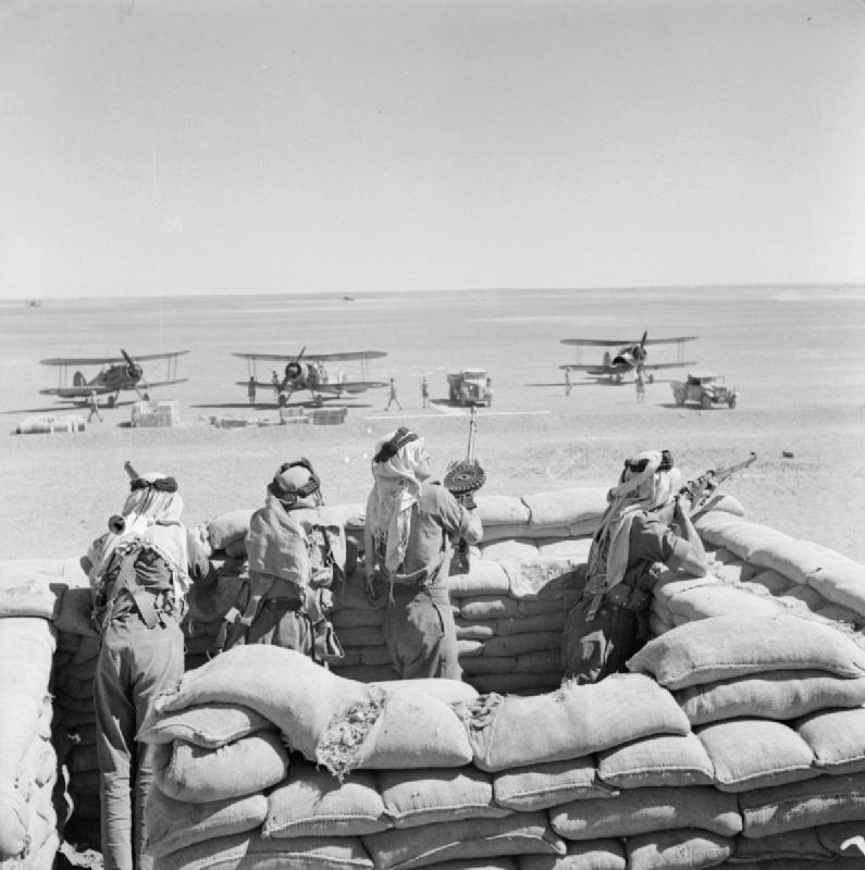 Arab Legionnaires guard the landing ground in Transjordan, as RAF Gloster Gladiators refuel on journey from Ismailia, Egypt, to besieged Habbaniya, Iraq, 8 May 1941 (Imperial War Museum: CM 774)