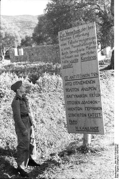 Sign erected by the Germans at Kandanos, Crete, which reads: “Kandanos was destroyed in retaliation for the bestial ambush murder of a paratrooper platoon and a half-platoon of military engineers by armed men and women.” (German Federal Archive: Bild 101I-779-0003-22)