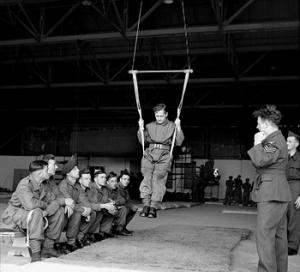 Inside a hangar, a British paratrooper learns to land correctly using a special harness, August 1942 (Imperial War Museum: H 22867)