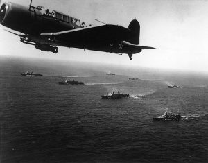 SB2U Vindicator scout bomber flying anti-submarine patrol over Convoy WS-12X en route for Cape Town, South Africa, 27 Nov 1941; note cruisers USS Vincennes and USS Quincy (US National Archives: 80-G-464654)