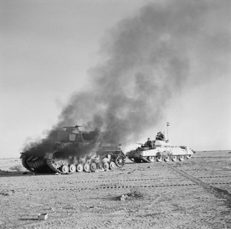 British Crusader tank passing a burning German Panzer IV in North Africa during Operation Crusader, 27 Nov 1941 (Imperial War Museum: E 6751)