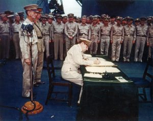 Gen. Douglas MacArthur signing the Japanese surrender documents aboard USS Missouri, 2 Sept 1945 (US National Archives: USA C-4627)