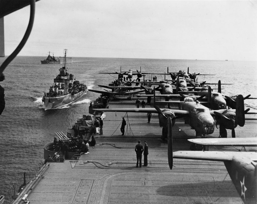 Aft flight deck of carrier USS Hornet en route to the Doolittle Raid, April 1942; destroyer USS Gwin and cruiser USS Nashville in background (US Naval History & Heritage Command: NH 53289) 