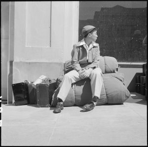 A boy and his personal effects at 2020 Van Ness Avenue as part of the contingent of 664 residents of Japanese ancestry, first to be evacuated from San Francisco on April 6, 1942 (US National Archives: 536059)