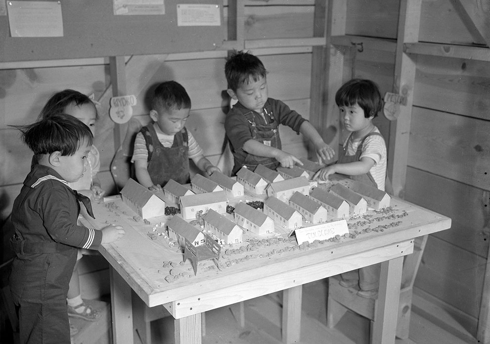 Japanese-American children playing with scale model of their home at Tule Lake Relocation Center, Newell, CA, 11 Sep 1942 (US National Archives)