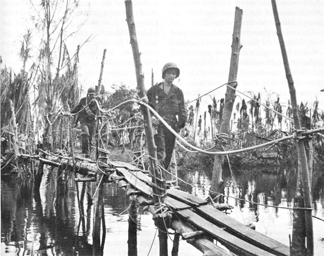 US troops crossing Japanese-built footbridge to Buna Mission over Entrance Creek, Papua New Guinea, December 1942 (US Army Center for Military History)