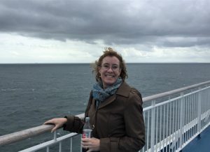 Sarah Sundin on ferry Mont St. Michel, with the shores of Normandy appearing on the horizon, September 2017