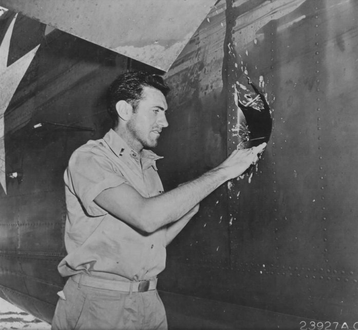 Lt. Louis Zamperini, bombardier, inspecting a hole in his B-24D Liberator, Superman, damaged over Nauru, 20 Apr 1943; photo taken at Funafuti in Gilbert Islands (US National Archives)