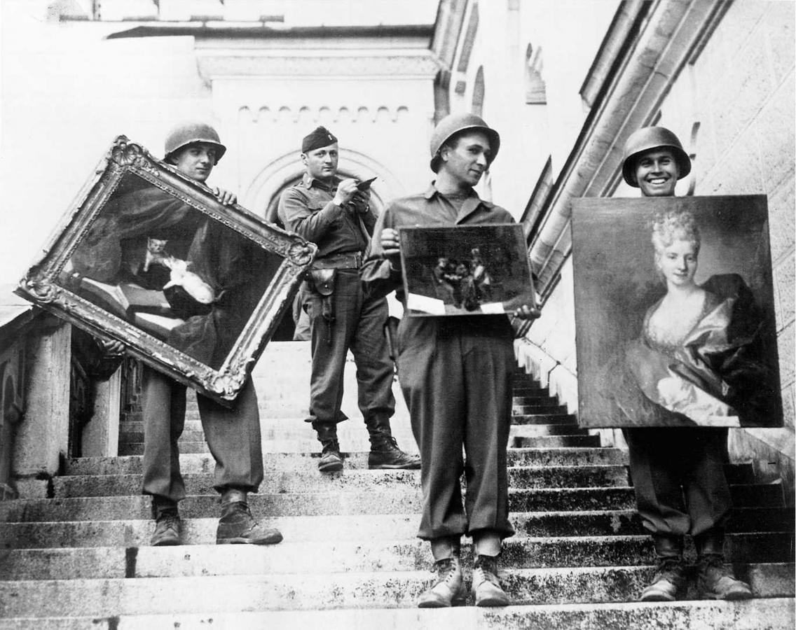 GIs hand-carry paintings in Neuschwanstein Castle under the supervision of Captain James Rorimer. (US National Archives)