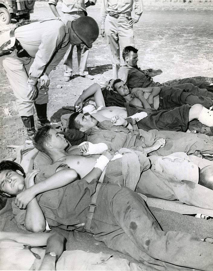 Gen. George Patton talking to wounded soldiers of the US 3rd Infantry Division waiting for air evacuation, 1943 (US National Archives RG-208-AA-158-A-015)