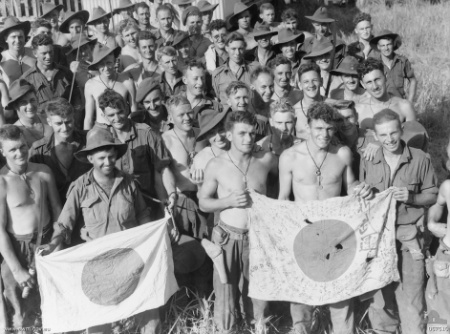 Soldiers from the 2/6th Independent Company display Japanese flags they captured during the battle of Kaiapit, 22 September 1943 (Australian War Memorial 057510)
