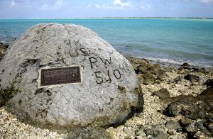 Memorial for the 98 US civilian contract POWs who were executed by the Japanese on 7 Oct 1943; an unidentified prisoner escaped and chiseled "98 US PW 5-10-43" on this rock before he was executed himself (US Air Force photo)