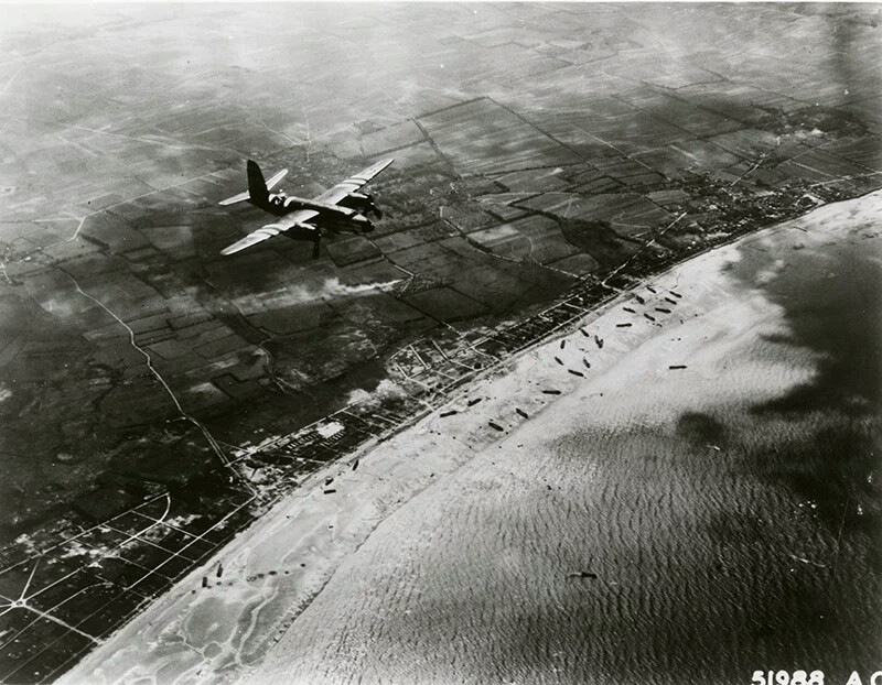 US B-26 Marauder over Utah Beach, 6 June 1944. The medium bomber has been specially marked for D-day with black and white stripes on the fuselage and wings, which were to identify itself as a friendly aircraft to ground units. (USAF photo)