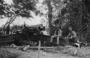Rangers 1st Sgt. Leonard “Len” Lomell and Staff Sgt. Jack Kuhn sitting on one of the 155mm guns they found and disabled on Pointe du Hoc, June 1944 (Public domain via Battle of Normandy Tours)