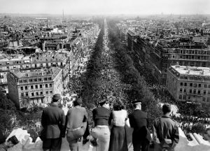 US Army personnel on top of l’Arc de Triomphe in Paris, France watching the celebration in the streets over the war in Europe coming to an end, 8 May 1945 (public domain via WW2 Database)